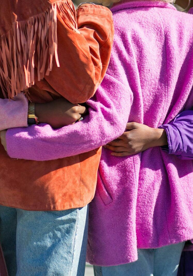 four person holding each others waist at daytime