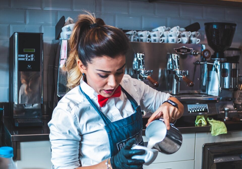 woman pouring liquid on mug